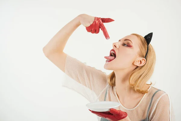Girl in kitten ears and red gloves with yoghurt isolated on white. Sexy cat woman lick milk from plate. Food and drink. Dieting and health. Cat woman eat sour cream. Ecology product and heath. — Stock Photo, Image