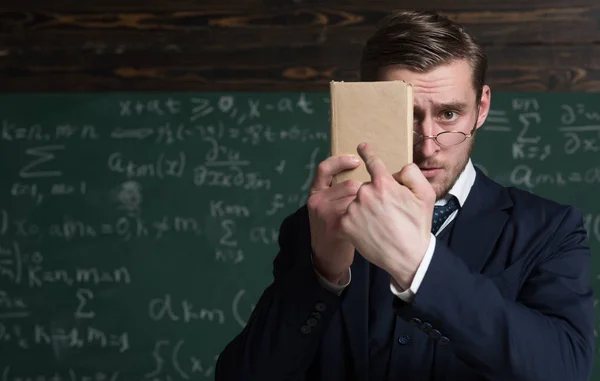 Sie sollten es besser lernen. Lehrertracht und Brille sehen pfiffig aus, Kreidehintergrund. Mann unrasiert hält Buch vor Gesicht. Lehrer beharrt auf Informationsbedarf. Bildungskonzept — Stockfoto