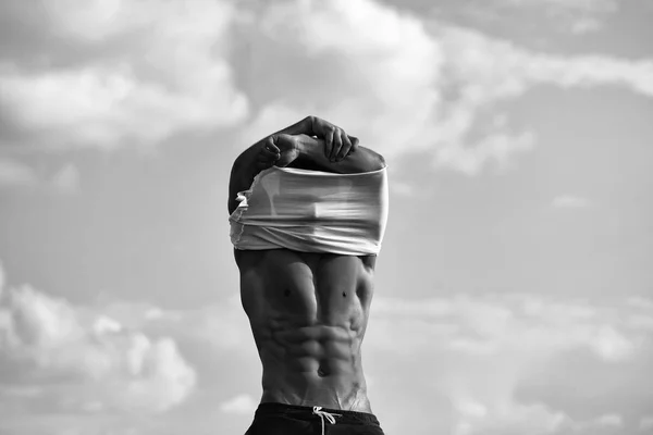 Cuerpo de hombre en forma. sexy muscular hombre desvestirse en cielo fondo — Foto de Stock