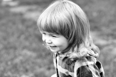 Yeşil çimenlerin üzerinde mutlu küçük çocuk