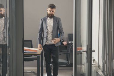 Kendine güvenen adam çalışma evinde rahat kıyafetli. Sakallı adam oda kapı dışarı bak. Cam duvarlı modern ofis iş adamı. İş ve ofis yaşam tarzı. Güven ve başarı kavramı