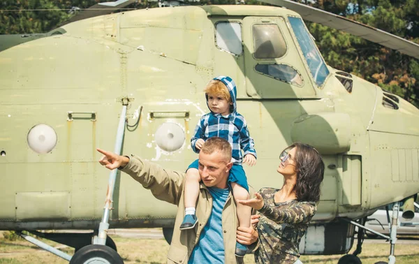 Concept de famille. Jeune famille en hélicoptère militaire. Membres de la famille à l'avion rétro. L'amour fait de vous une famille — Photo
