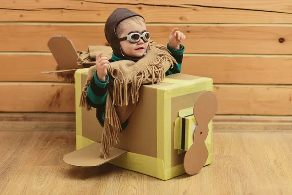 Little boy child play in cardboard plane, childhood.