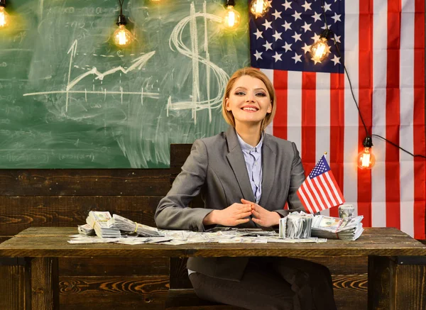 Kobieta z pieniędzy banknotów w szkole z amerykańską flagę. — Zdjęcie stockowe