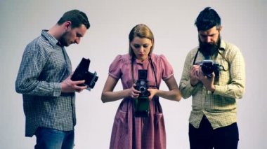 Üç genç insanlar eski fotoğraf makinesi vasıl arıyoruz. Antika kavramı. Fotoğrafçılar nadir kameralar ile.