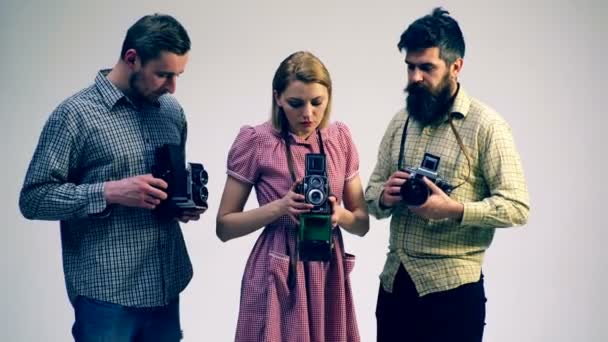 两个男孩和一个女孩研究电影旧相机。胶片相机概念. — 图库视频影像