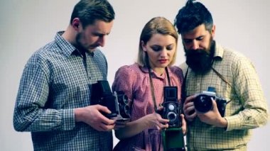 İki adam ve bir kız eski kameralar ellerini tutun. Photosprint eğitim kavramı. Fotoğraf ve kamera eğitim süreci