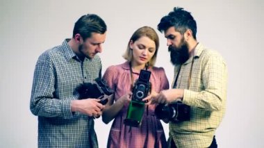 Bir grup genç insan antika fotoğraf makinesi dikkate alınarak. Antika şeyler kavramı. Fotoğrafçılar Fotoğraf sürecinde.