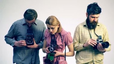 Eski fotoğraf makinesi. Stüdyo çekim kavramı. Üç fotoğrafçılar fotoğraf makinelerine ayarlama.