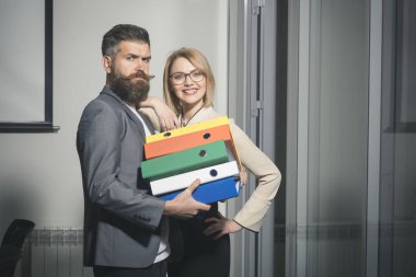 Hipster bağlayıcı ofisinde yürütmek için seksi kadın yardım. Hipster adam ve işkadını belgelerle, iş işbirliği ve ekip çalışması