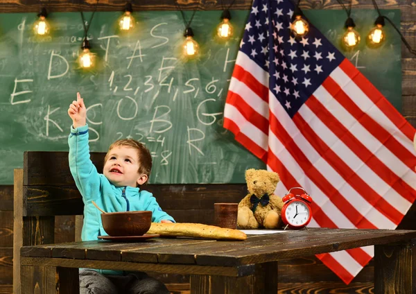 Kleiner kaukasischer Junge bei der amerikanischen Flagge am Unabhängigkeitstag. — Stockfoto