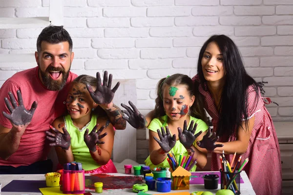 Famille heureuse montrant les mains colorées dans les peintures — Photo