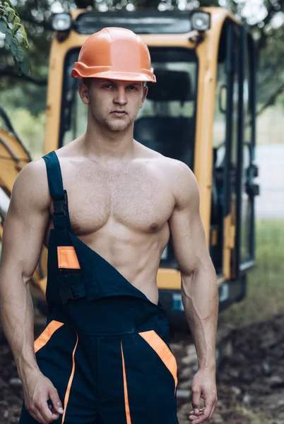 Operator concept. Excavator operator on construction site. Muscular operator in working uniform. Machine operator with digger — Stock Photo, Image