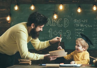 İngilizce dilbilgisi ders. Küçük çocuk sınıfta İngilizce dilbilgisi öğrenin. Baba oğluna İngilizce dilbilgisi öğretmek. İngilizce gramer kitapları.