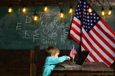 E-öğrenme ya da online kurslar ev okullaşma. Dizüstü bilgisayar için iş vasıl Amerikan bayrağı ile küçük çocuk. Vatanseverlik ve özgürlük. ABD Bağımsızlık Günün kutlu olsun. Okul çocuk 4 Temmuz derste