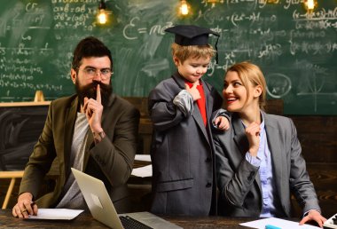 Modern öğretmen hippi matematik formülü ile büyük yazı tahtası üzerinde yazılı. Kitaplığındaki kitap okuyan üniversite öğrencileri. İyi öğretmenler sık sık iletişim ustalar vardır. Bireyin özel ders.