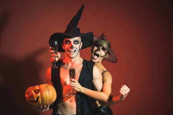 Halloween coppia con trucco su felice faccia tenere zucca — Foto Stock