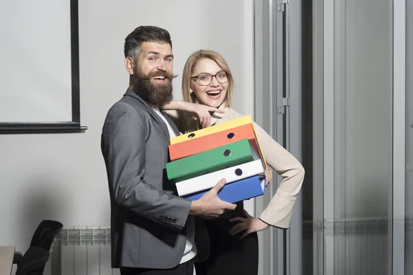 Jolie femme d'affaires portant pile de dossiers avec un collègue au bureau — Photo