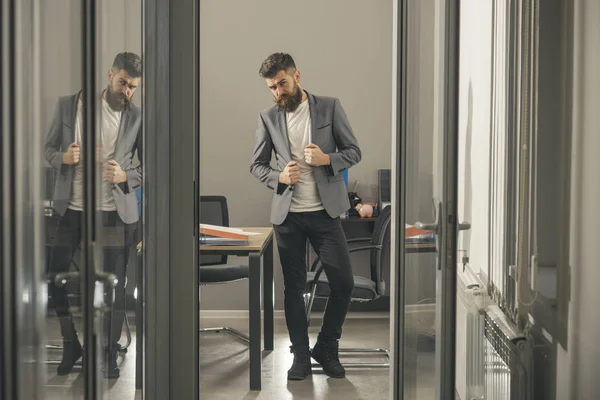 Skäggig man utkik kontor dörr. Skäggig man i moderna kontor med glasväggar, business livsstil — Stockfoto