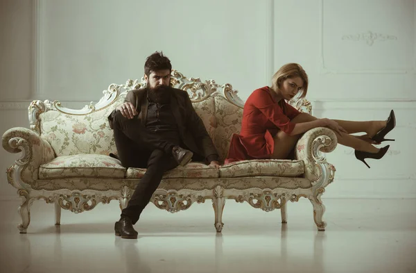 man with woman on sofa. bearded man with girl. man fashion model and sexy lady. business man relaxing with secreatry. confidence and charisma.