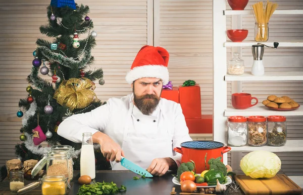 Chef homme dans santa claus chapeau cuisine . — Photo