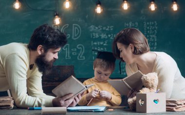 Dilbilgisi ders. Küçük çocuk sınıf dilbilgisi öğrenin. Annem ve babam dilbilgisi oğluna öğretmek. İngilizce gramer kitapları