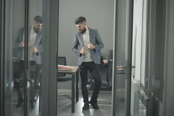 Hipster i moderna kontor med glasväggar. Skäggig man sett i dörren. Självsäker affärsman i casual kostym på arbetsplats. Business och office livsstil. Förtroende och framgång koncept — Stockfoto