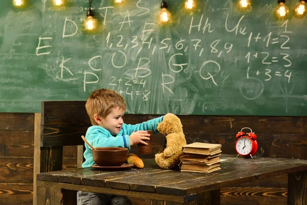 Drink menu. Little child feed teddy bear with water, drink menu. Boy enjoy drink menu with toy friend in classroom. Drink menu for health. Every drop of water matters