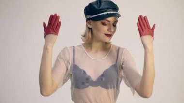 Siyah deri şapkalı kız yüzünü onunla hangi ellerde kırmızı deri eldiven giymiş kapsar. Moda kavramı.