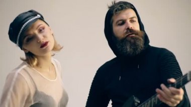 Şarkı ve gri bir arka plan üzerinde izole gitar rock çift. Çift gitar ile sarılma aşık. Rock and roll kavramı.