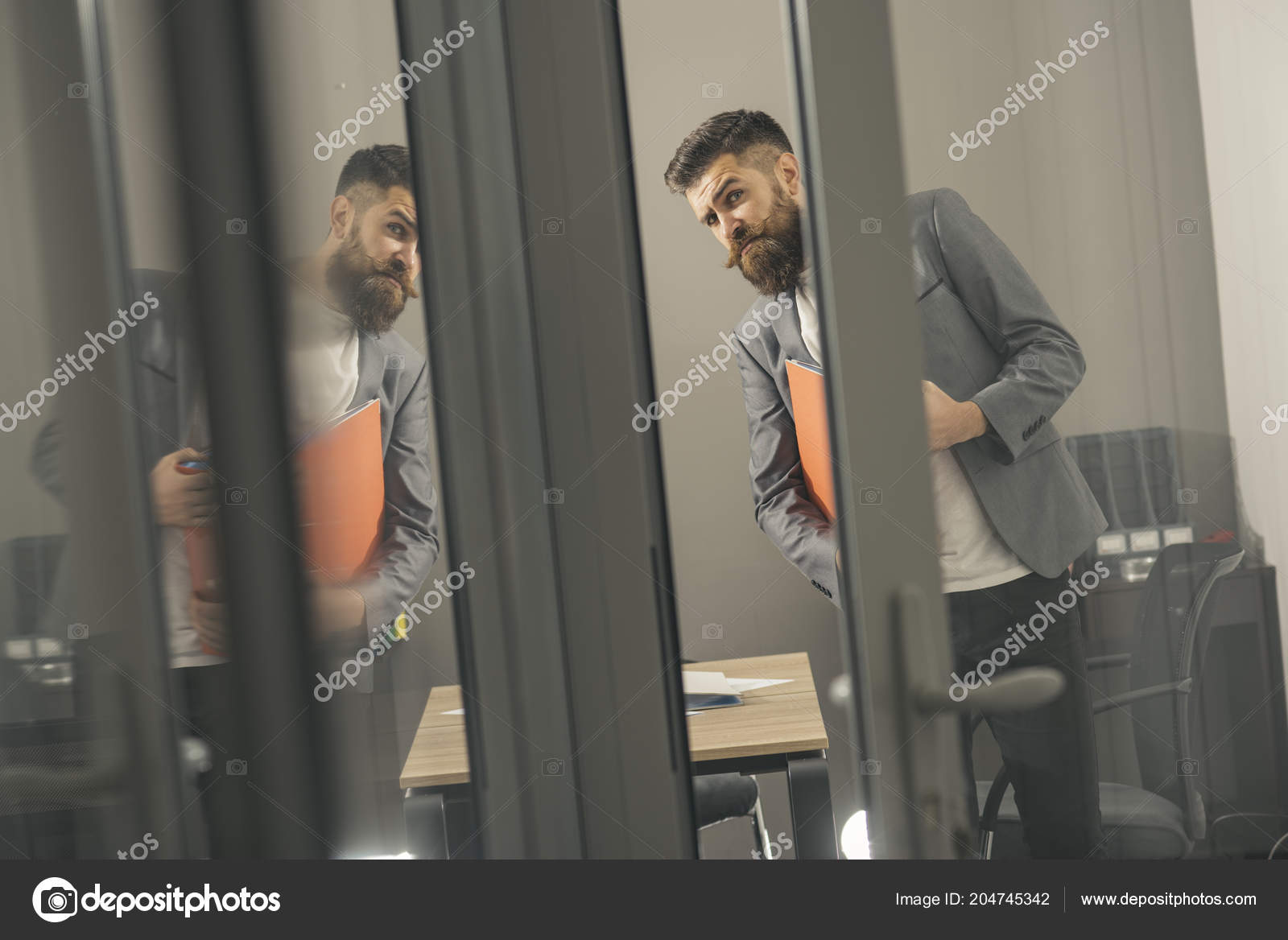 Curious Young Businessman Looking Through Door In Office Stock