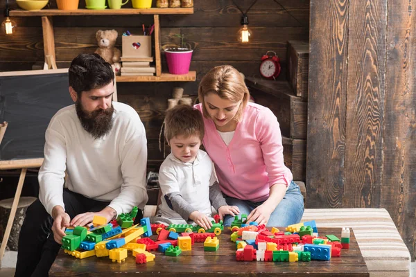 Concepto de juego. Hijo con madre y padre jugar juego de construcción. Pequeño niño aprendiendo a través del juego. Aprender juego . — Foto de Stock