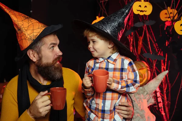 Halloween Boy kid with happy face and bearded man at pumpkin.