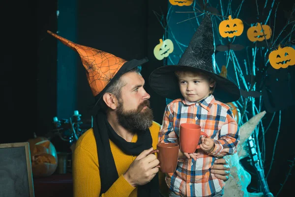 Halloween Father and small son drink from tea or milk cup.