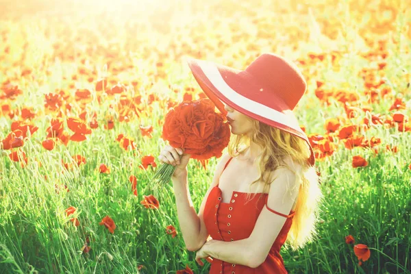 woman in field of poppy seed in retro hat