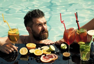 Kokteyl ve sakallı bir adam havuzda.