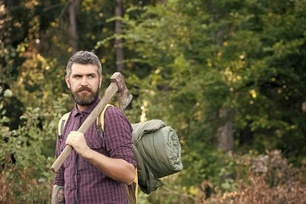 Homem lenhador com rosto barbudo segurar mochila e machado — Fotografia de Stock