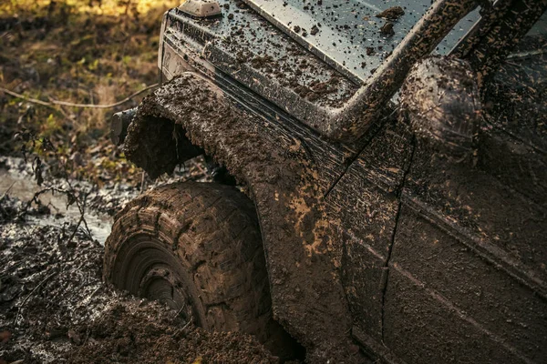 Araba parçası kir içinde sıkışmış, yakın çekim.