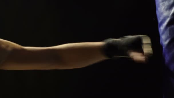 Představa boxu. Mladý boxer vlaky na modré hruška izolovaných na černém pozadí. — Stock video