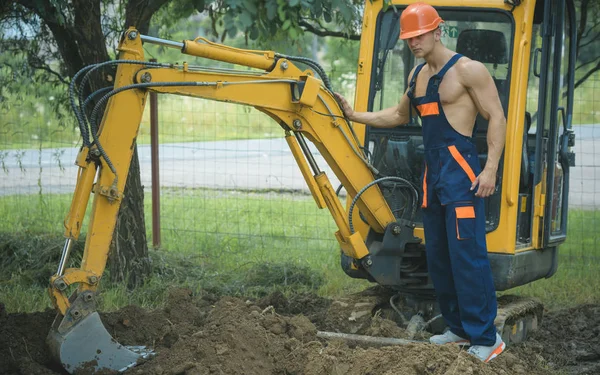 Concept d'excavation. Pelle homme pour excavation au sol. Exploitant de pelleteuse travailler sur le site d'excavation. Excavation et construction — Photo