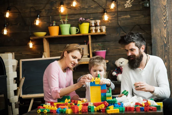 Concepto de juego. Aprendiendo juego. Hijo con madre y padre jugar juego de construcción. Niños pequeños aprendiendo a través del juego —  Fotos de Stock