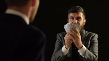 Yolsuzluk kavramı. Takım elbiseli bir adam başka bir adam önünde para sahiptir.