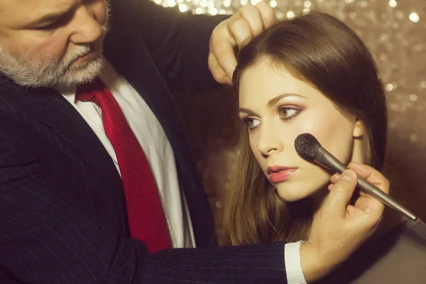 Visagiste uomo applicando polvere con pennello sul viso della ragazza — Foto Stock