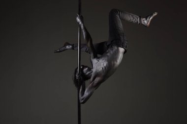 Güçlü dansçı kutup. Özgürlük. Metal yüzey ile seksi maço. Hareketleri elinde. Pilon üzerinde dans gümüş gövde sanat kaslı adam. Atletik erkekleri pilon üzerinde akrobatik öğeleri gösteriyor. Pole dans spor.