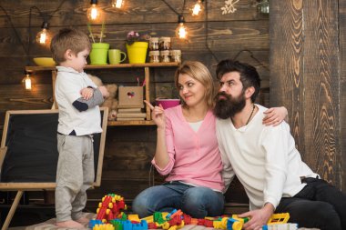 Oyuncak kavramı. Anne ve baba ile oğlu inşa yapısı ile oyuncak inşaat ayarlayın. Çocuklar için eğitici oyuncak. Küçük çocuk oyuncak tuğla ile oynamak