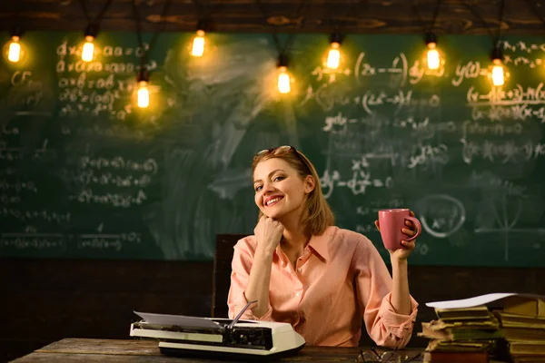 Office liv koncept. Office livet av kvinnan dricka kaffe medan du skriver på retro skrivmaskin. — Stockfoto