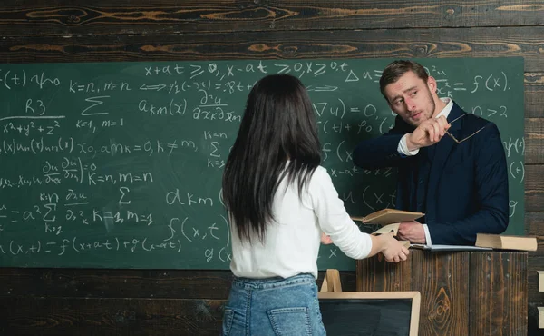 Behandlingen är min hobby. Bakre Visa kvinna ge boken till mannen på tavlan. Genius lärare med glasögon och boken titta på flicka student. Skoldag. Dela åsikter. Tillbaka till skolan — Stockfoto