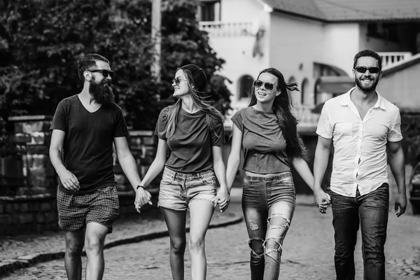 Svago estivo di amici felici e sorridenti che camminano lungo la strada di mattoni — Foto Stock