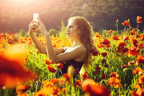 電話とポピーの作る selfie 写真のフィールドの女の子 — ストック写真