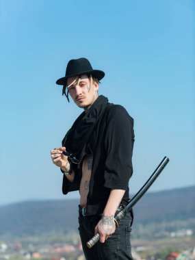 Açık giysili dövmeli gövde siyah şapkalı savaşçı